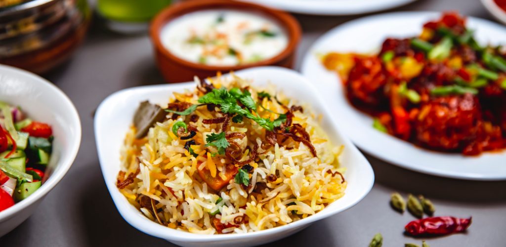 side-view-rice-garnish-with-fried-onion-carrot-greens-chili-pepper-table (1)